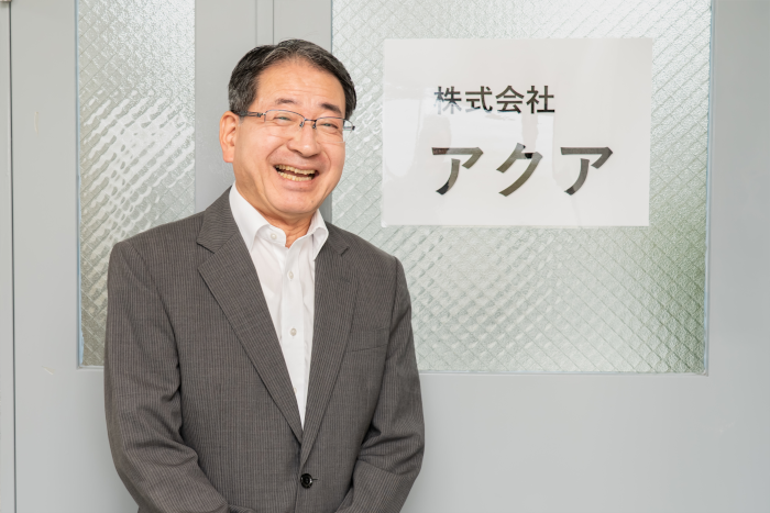 株式会社アクアのドアの前に立つ代表取締役、菊池等氏