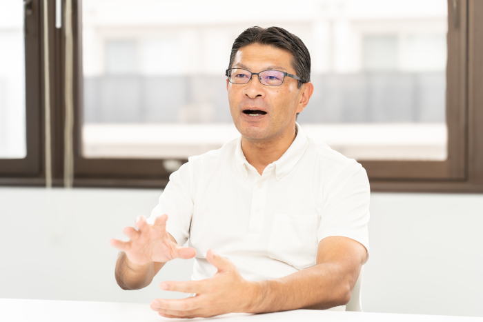 東京の賃貸オフィスの利用についてのインタビューを受ける株式会社ディジタルの執行役員、熊倉慎一氏